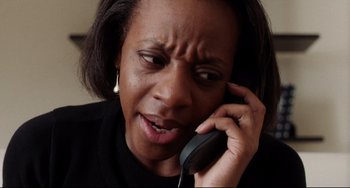 Movie still from “Secrets & Lies” (1996), directed by Mike Leigh – An older woman talking on a phone with a frowning look on her face; Close Up shot, High angle