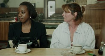 Movie still from “Secrets & Lies” (1996), directed by Mike Leigh – Two women are sitting at a table with coffee; Medium shot, Over the shoulder angle