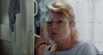 Movie still from “Secrets & Lies” (1996), directed by Mike Leigh – A woman smoking a cigarette in front of a mirror; Close Up shot, Over the shoulder angle