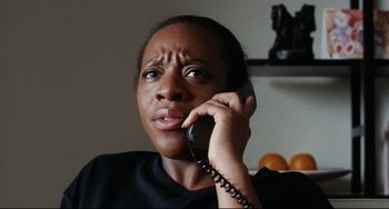 Movie still from “Secrets & Lies” (1996), directed by Mike Leigh – A woman talking on a phone while sitting in a chair; Close Up shot, Low angle