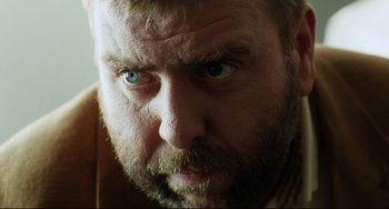 Movie still from “Secrets & Lies” (1996), directed by Mike Leigh – A person with a beard and blue eyes; Close Up shot, Low angle