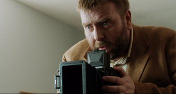 Movie still from “Secrets & Lies” (1996), directed by Mike Leigh – A person taking a picture with a camera; Close Up shot, Low angle
