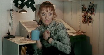 Movie still from “Secrets & Lies” (1996), directed by Mike Leigh – A woman is holding a coffee mug in her hands; Medium shot, High angle