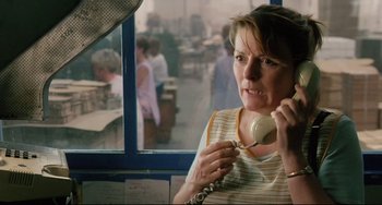 Movie still from “Secrets & Lies” (1996), directed by Mike Leigh – A woman holding a phone up to her ear while standing in front of a window; Close Up shot, High angle