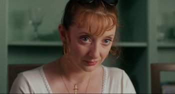 Movie still from “Secrets & Lies” (1996), directed by Mike Leigh – A person wearing glasses and a necklace; Close Up shot, High angle