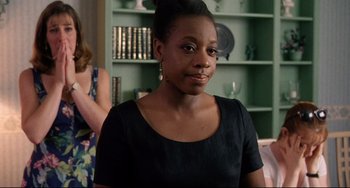 Movie still from “Secrets & Lies” (1996), directed by Mike Leigh – A woman in a black dress is smiling for the camera; Close Up shot, Over the shoulder angle
