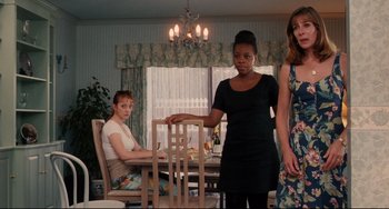 Movie still from “Secrets & Lies” (1996), directed by Mike Leigh – A group of people standing around a dining room table; Medium shot, Over the shoulder angle