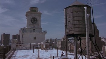 Movie still from “Serendipity” (2001), directed by Peter Chelsom – A large clock tower in the middle of a snowy city; Extreme Wide shot, High angle