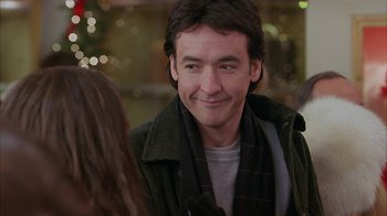 Movie still from “Serendipity” (2001), directed by Peter Chelsom – A person smiling at someone; Close Up shot, Over the shoulder angle