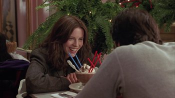 Movie still from “Serendipity” (2001), directed by Peter Chelsom – A woman sitting in front of a bowl of ice cream; Medium shot, Over the shoulder angle