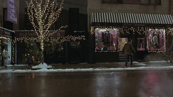 Movie still from “Serendipity” (2001), directed by Peter Chelsom – Two people walking down the street in front of a store at night; Wide shot, Over the shoulder angle
