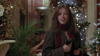 Movie still from “Serendipity” (2001), directed by Peter Chelsom – A young woman holding a cell phone while standing in front of a christmas tree; Medium shot, Over the shoulder angle