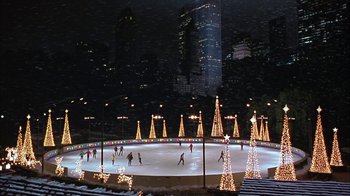 Movie still from “Serendipity” (2001), directed by Peter Chelsom – People skating on the ice rink at night; Extreme Wide shot, High angle