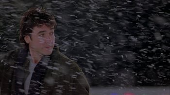 Movie still from “Serendipity” (2001), directed by Peter Chelsom – A young man standing in the snow looking at the camera; Medium shot, Over the shoulder angle
