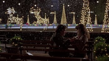 Movie still from “Serendipity” (2001), directed by Peter Chelsom – Two people sitting on a wooden bench in the snow; Wide shot, Over the shoulder angle