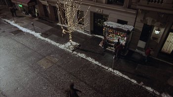 Movie still from “Serendipity” (2001), directed by Peter Chelsom – A man standing next to a tree on the side of the street; Extreme Wide shot, High angle