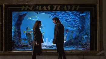 Movie still from “Serendipity” (2001), directed by Peter Chelsom – A man and a woman standing in front of an aquarium; Wide shot, High angle