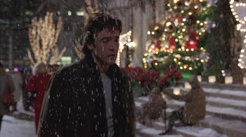 Movie still from “Serendipity” (2001), directed by Peter Chelsom – A man standing in front of a christmas tree; Medium shot, Low angle