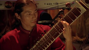 Movie still from “Serendipity” (2001), directed by Peter Chelsom – A man holding a guitar in his hands; Close Up shot, Low angle