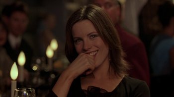 Movie still from “Serendipity” (2001), directed by Peter Chelsom – A woman smiles while sitting at a dinner table; Close Up shot, Over the shoulder angle