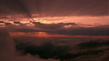 Movie still from “Serendipity” (2001), directed by Peter Chelsom – The sun is setting over the clouds in the sky; Extreme Wide shot, Low angle