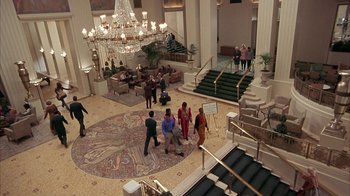 Movie still from “Serendipity” (2001), directed by Peter Chelsom – A group of people standing in a lobby area; Extreme Wide shot, High angle