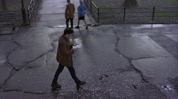 Movie still from “Serendipity” (2001), directed by Peter Chelsom – A man is walking on the sidewalk while holding a cell phone; Wide shot, High angle