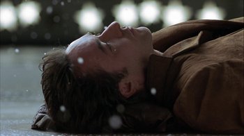 Movie still from “Serendipity” (2001), directed by Peter Chelsom – A man laying on the ground with his eyes closed; Close Up shot, High angle