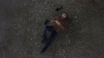 Movie still from “Serendipity” (2001), directed by Peter Chelsom – A man laying on the ground in the snow; Wide shot, Overhead angle
