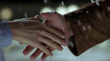 Movie still from “Serendipity” (2001), directed by Peter Chelsom – Two people holding hands in the snow; Extreme Close Up shot, Over the shoulder angle