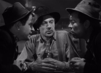 Movie still from “Sergeant York” (1941), directed by Howard Hawks – A group of men standing around a man holding a drink; Medium shot, Low angle