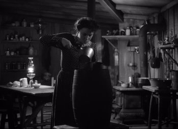 Movie still from “Sergeant York” (1941), directed by Howard Hawks – A woman in an old - fashioned kitchen pouring a drink; Medium shot, Low angle