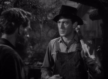 Movie still from “Sergeant York” (1941), directed by Howard Hawks – A man wearing a hat holding an open umbrella; Medium shot, Over the shoulder angle