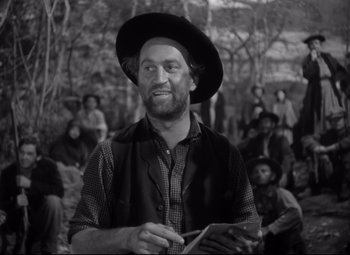 Movie still from “Sergeant York” (1941), directed by Howard Hawks – A man with a hat and a beard is holding a tablet; Medium shot, Over the shoulder angle
