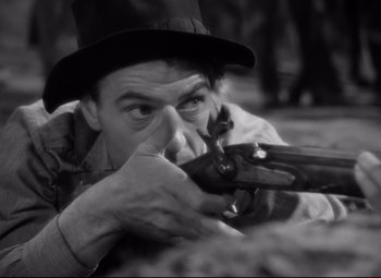 Movie still from “Sergeant York” (1941), directed by Howard Hawks – A man in a hat is holding a gun; Close Up shot, High angle