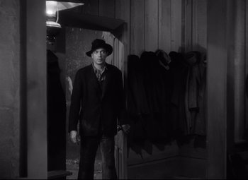 Movie still from “Sergeant York” (1941), directed by Howard Hawks – A black and white photo of a man in a suit and hat; Medium shot, Over the shoulder angle
