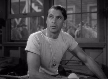 Movie still from “Sergeant York” (1941), directed by Howard Hawks – A man sitting at a table in a room; Close Up shot, Over the shoulder angle