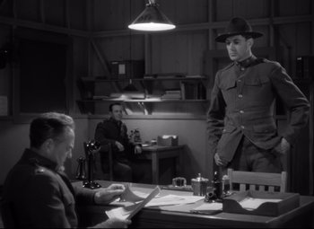 Movie still from “Sergeant York” (1941), directed by Howard Hawks – A man in a hat is standing at a table; Medium shot, Low angle