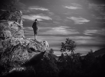 Movie still from “Sergeant York” (1941), directed by Howard Hawks – A man standing on top of a mountain looking at the sky; Extreme Wide shot, Low angle