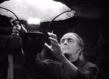 Movie still from “Sergeant York” (1941), directed by Howard Hawks – A black and white photo of a man working with a lamp; Medium shot, Low angle