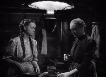 Movie still from “Sergeant York” (1941), directed by Howard Hawks – Two women are standing at a table in a kitchen; Medium shot, Over the shoulder angle