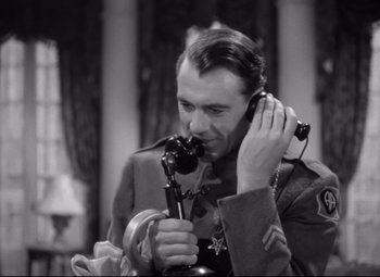 Movie still from “Sergeant York” (1941), directed by Howard Hawks – An old photo of a man holding a phone up to his ear; Close Up shot, High angle