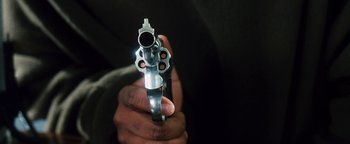 Movie still from “Set It Off” (1996), directed by F. Gary Gray – A person holding a gun in their hand; Extreme Close Up shot, Low angle