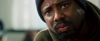 Movie still from “Set It Off” (1996), directed by F. Gary Gray – A person with a beard wearing a hat; Close Up shot, Low angle