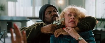 Movie still from “Set It Off” (1996), directed by F. Gary Gray – A man with a gun on a woman's shoulder; Close Up shot, High angle