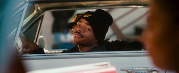 Movie still from “Set It Off” (1996), directed by F. Gary Gray – A young man in a car wearing a black hat; Close Up shot, Low angle