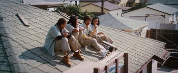 Movie still from “Set It Off” (1996), directed by F. Gary Gray – A group of people sitting on top of a roof; Wide shot, High angle