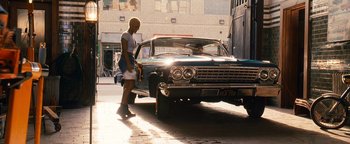 Movie still from “Set It Off” (1996), directed by F. Gary Gray – A woman standing in front of a car on a city street; Wide shot, Low angle