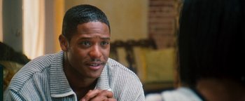 Movie still from “Set It Off” (1996), directed by F. Gary Gray – A person sitting in a room; Close Up shot, Over the shoulder angle