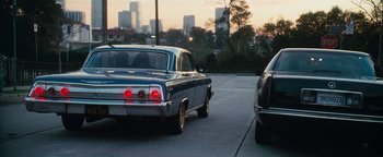 Movie still from “Set It Off” (1996), directed by F. Gary Gray – Two cars are driving down the street in a city; Wide shot, High angle